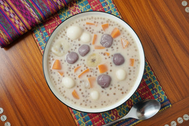 Bowl of sago pearl dessert with a spoon on a textured surface